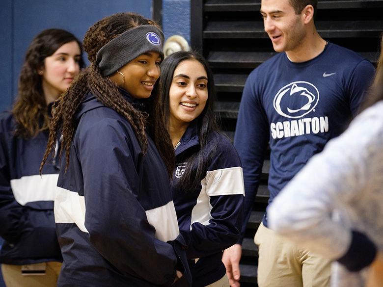 four students in Penn State attire speak with New Students